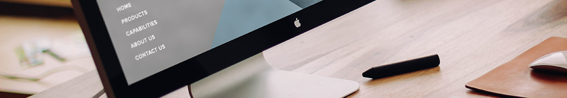 Bottom slice of a monitor, desk and office paraphernalia.